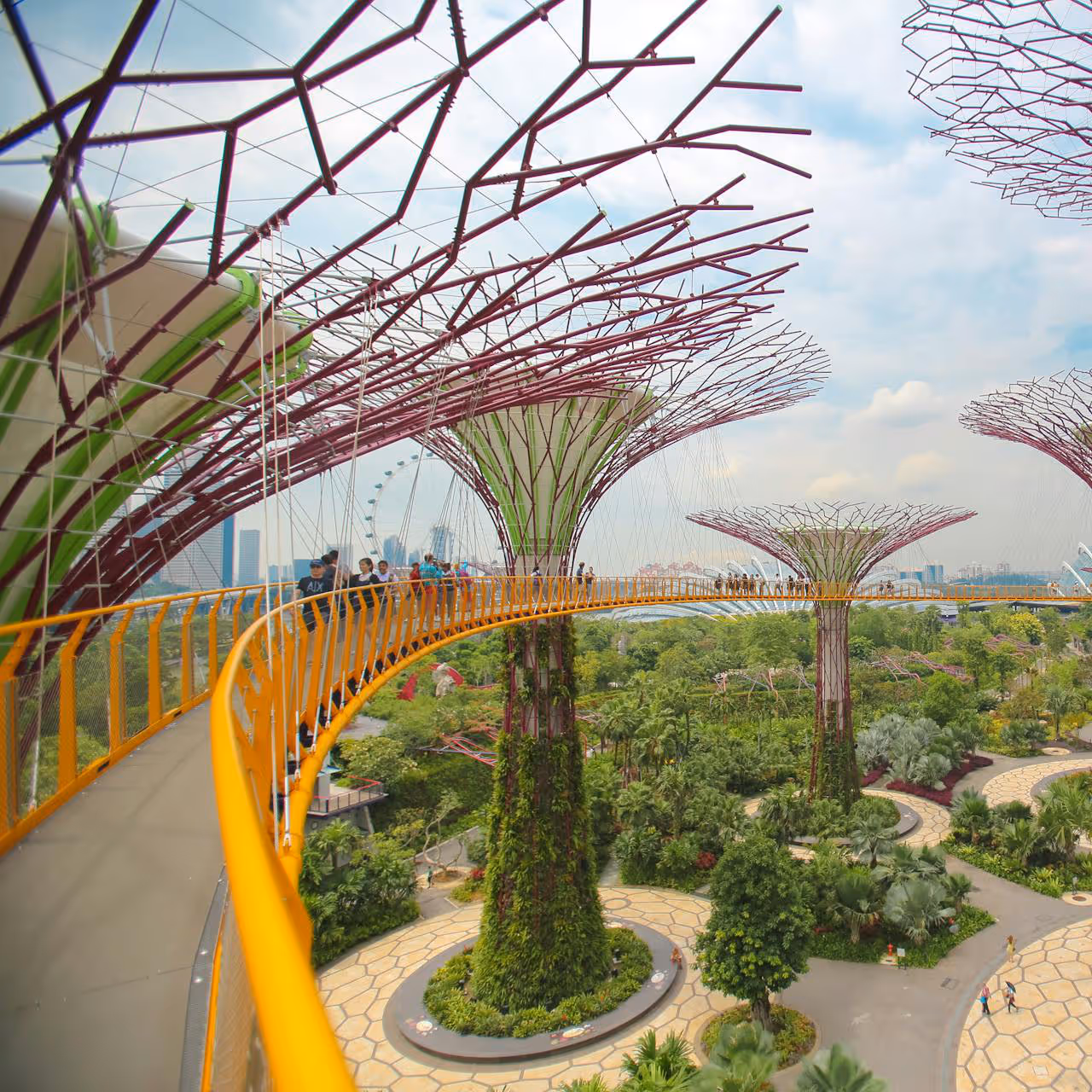 A modern biophilic publish park with plant-like structures supporting an elevated walkway.