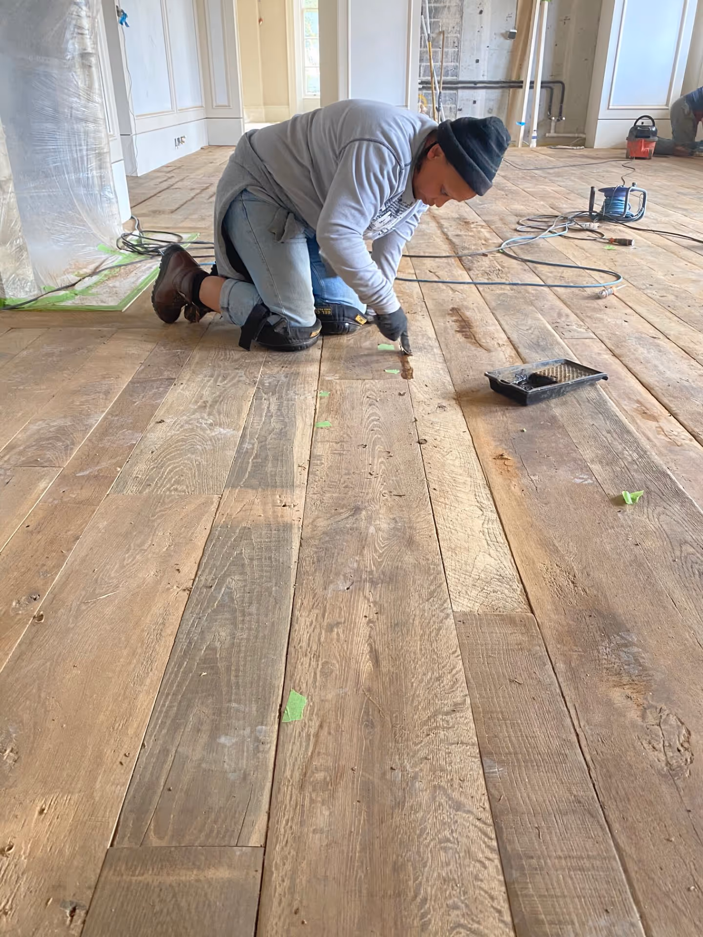 A man restoring an existing wooden floor.