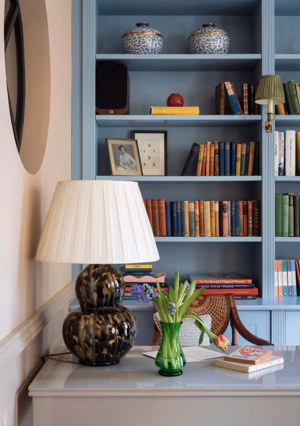 A traditional living room with fitted bookshelves painted pale blue.
