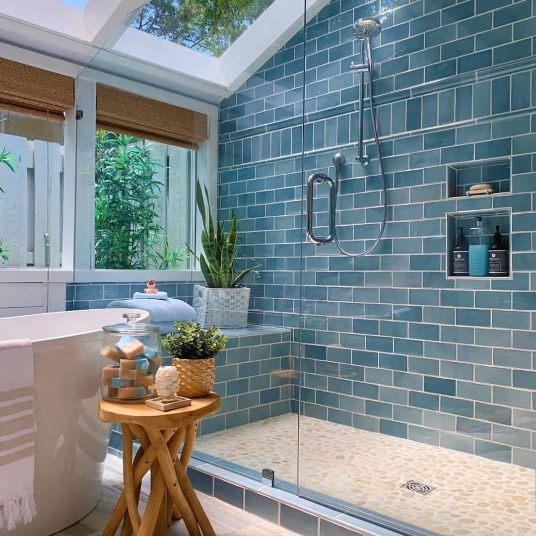 A bathroom with an ocean blue tiled shower enclosure and pebble mosaic shower tray.