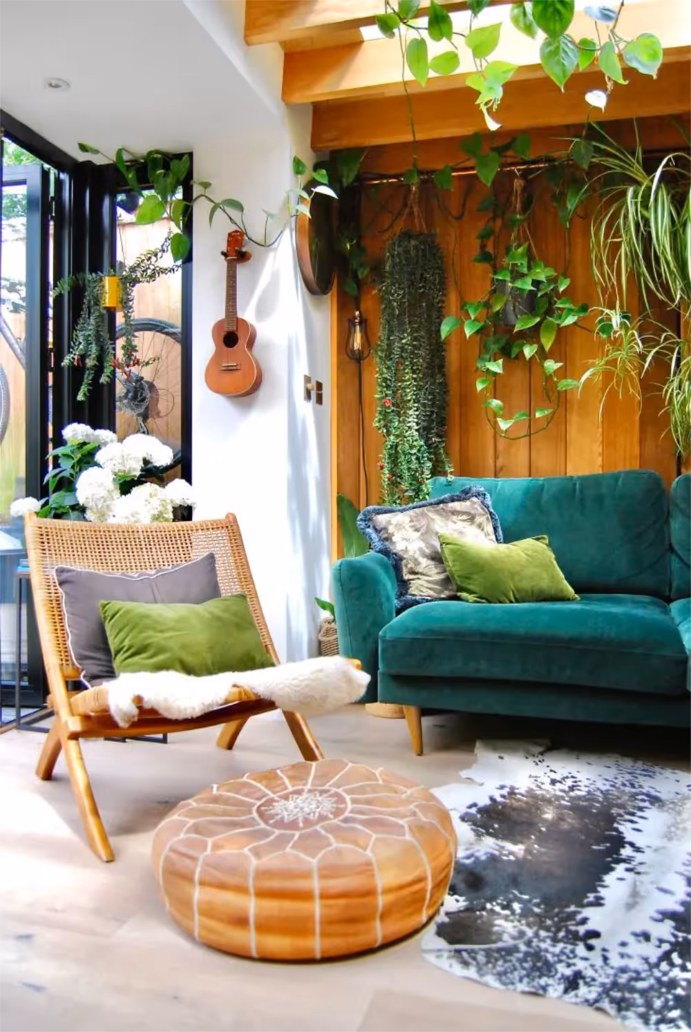 A biophilic designed lounge with wooden panelling and a teal velvet sofa.