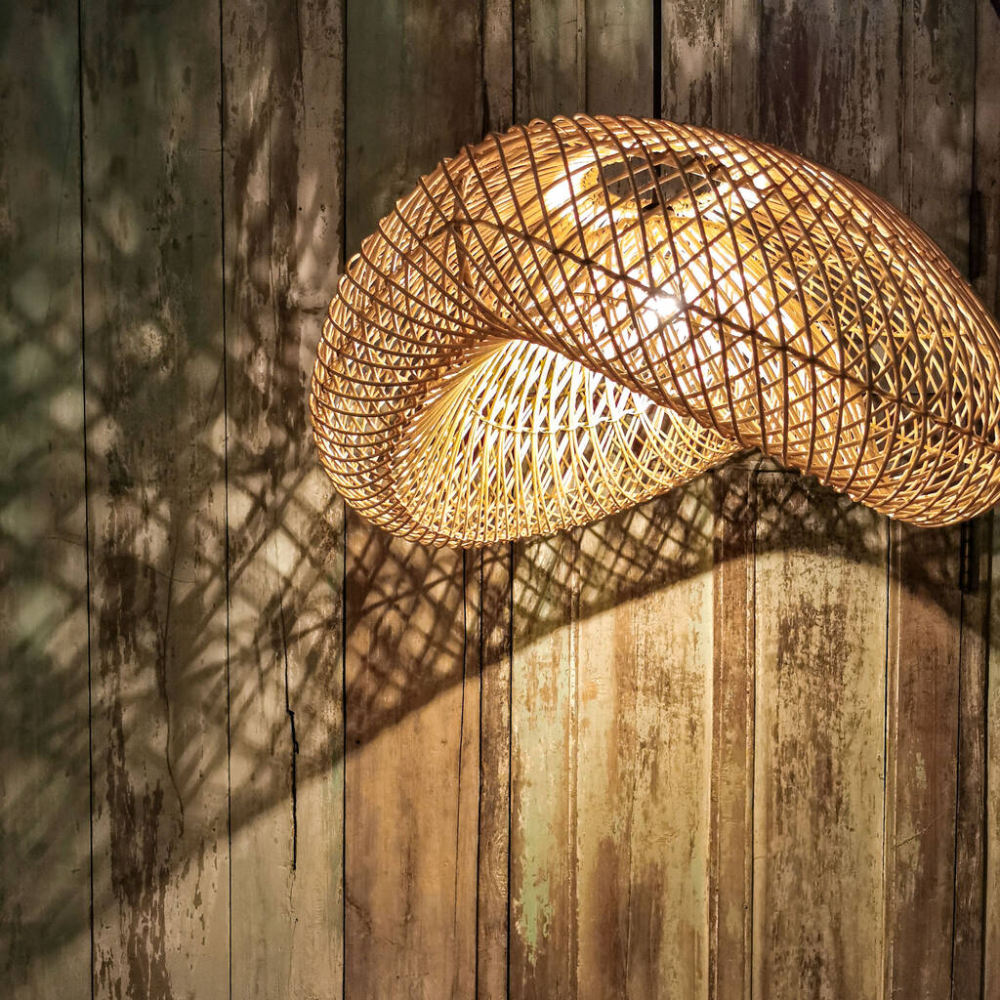 A rattan pendant light shade casting pretty shadows on a timber clad wall.