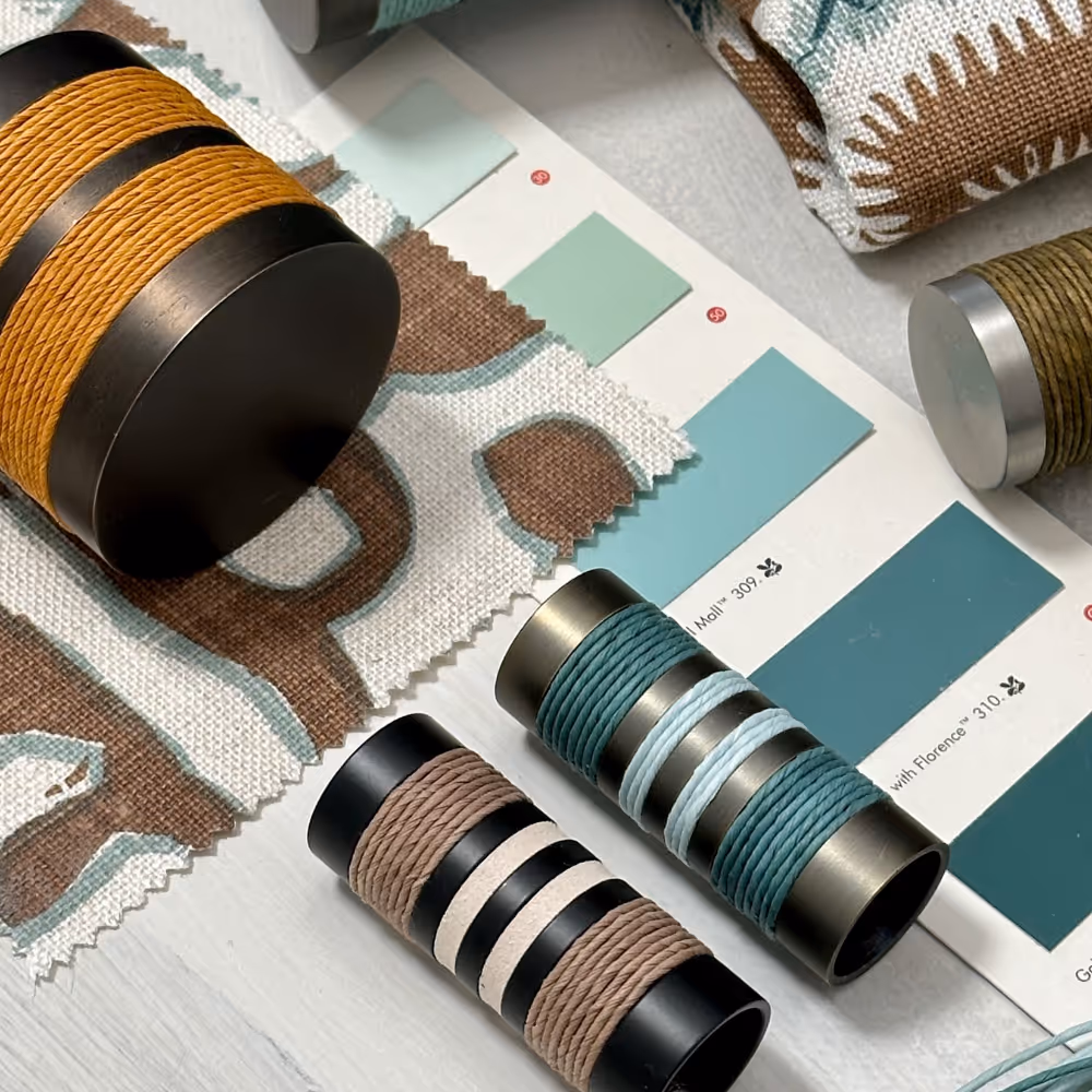 A selection of curtain pole finials and paint charts in teal green and brown.