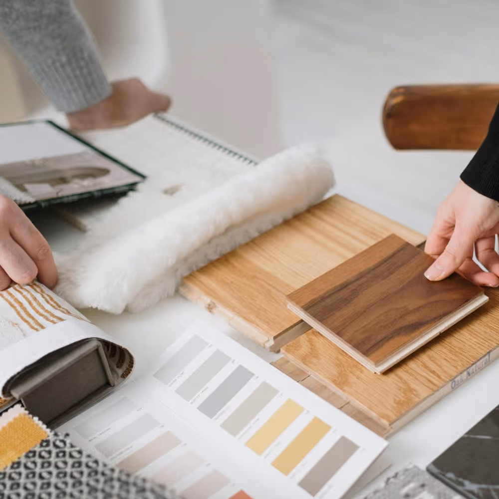 Two people mulling over samples of wooden flooring and wall colours.