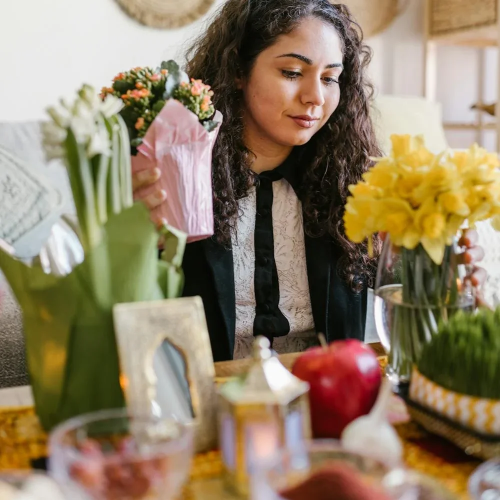 An woman preparing the haft seen table for the Iranian New Year.
