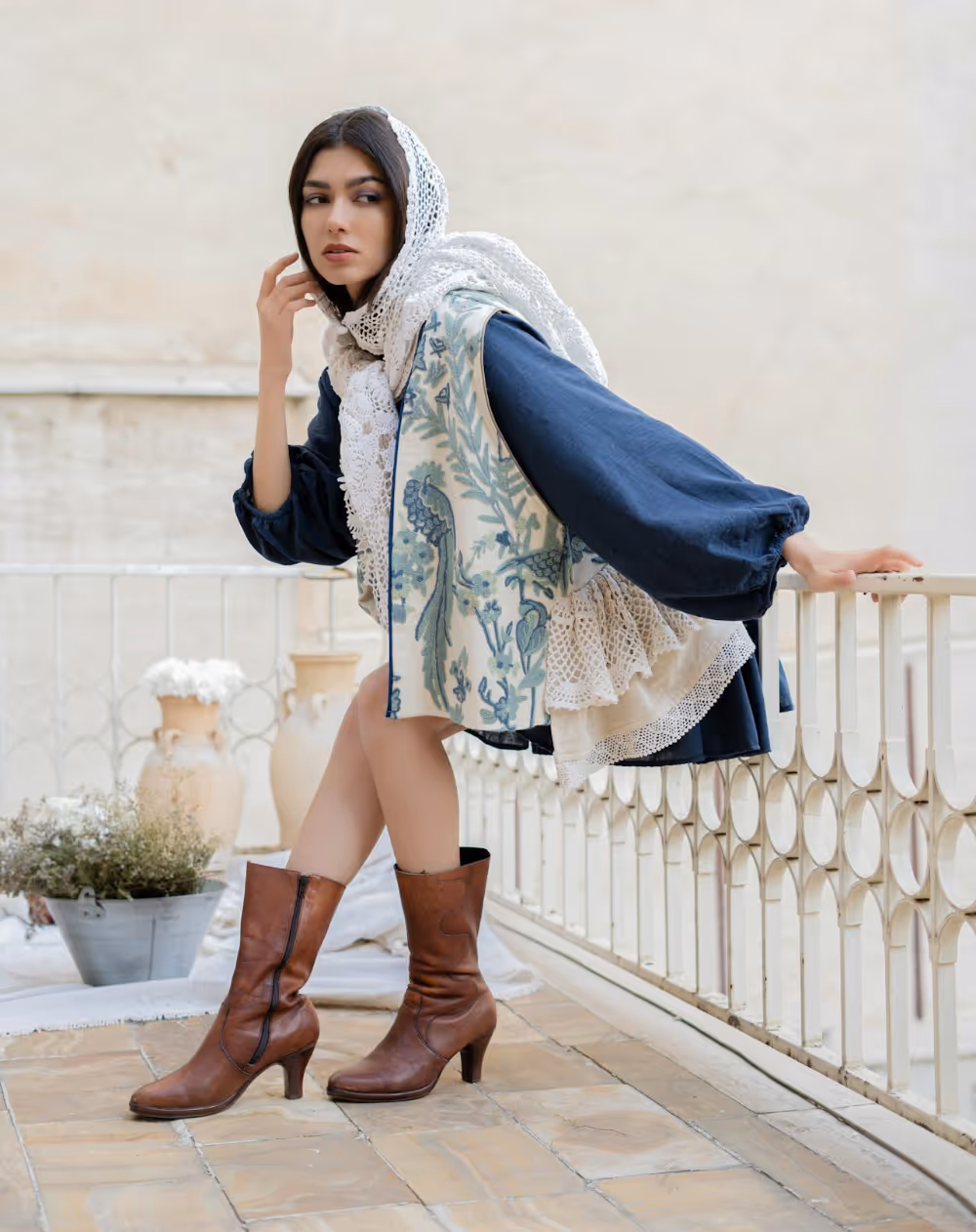A fashionable Iranian woman leaning against a stone balustrade.