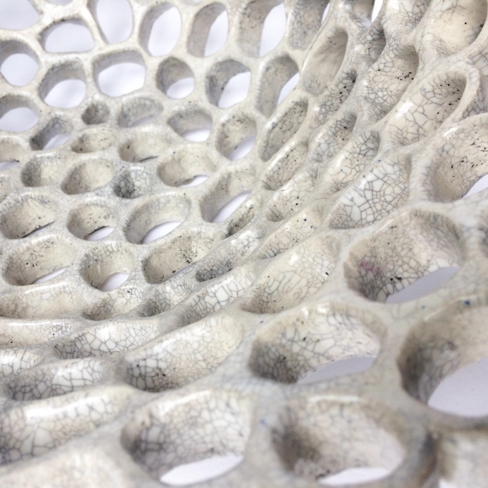 A close up of a ceramic bowl with decorative holes