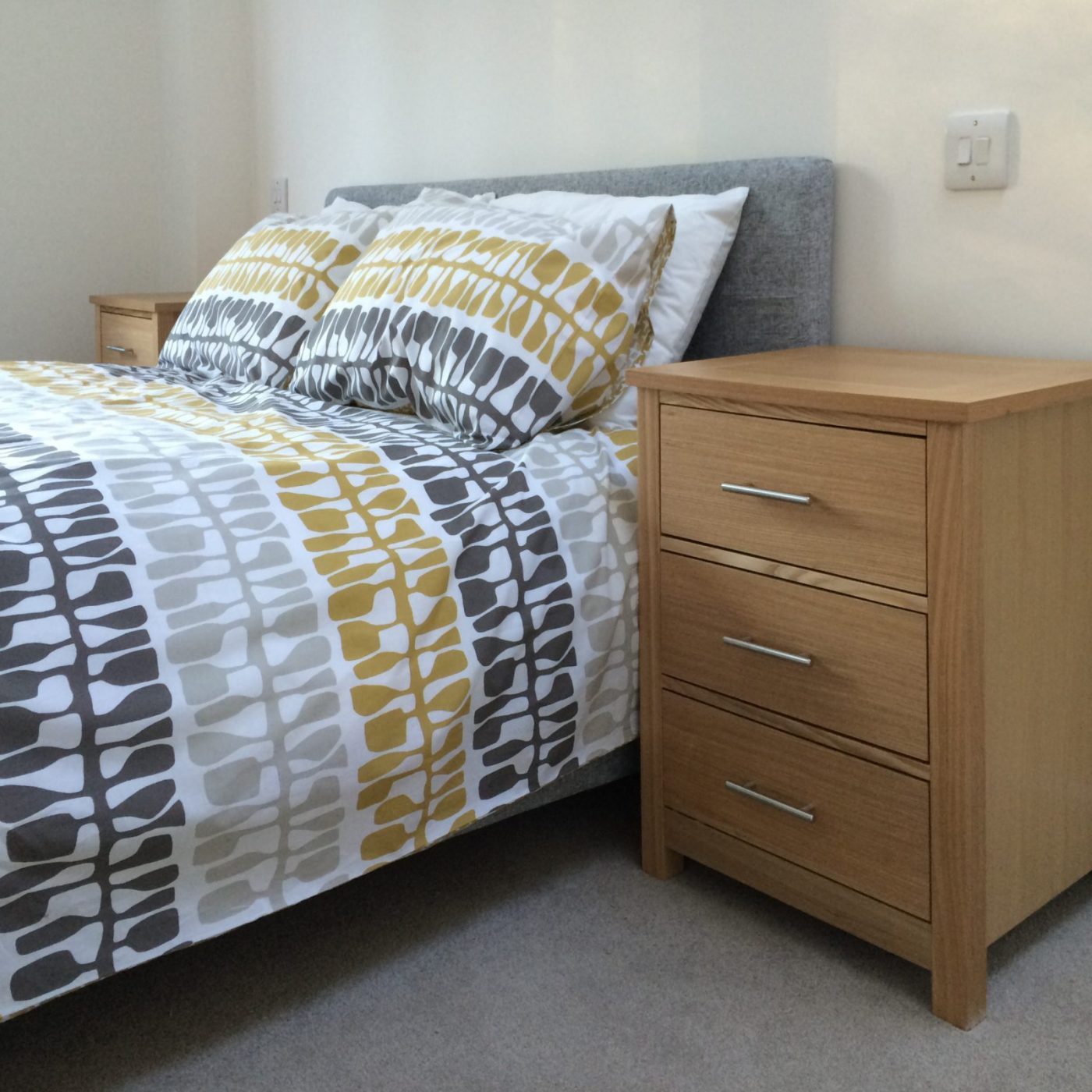 Bedroom with oak bedside and patterned duvet