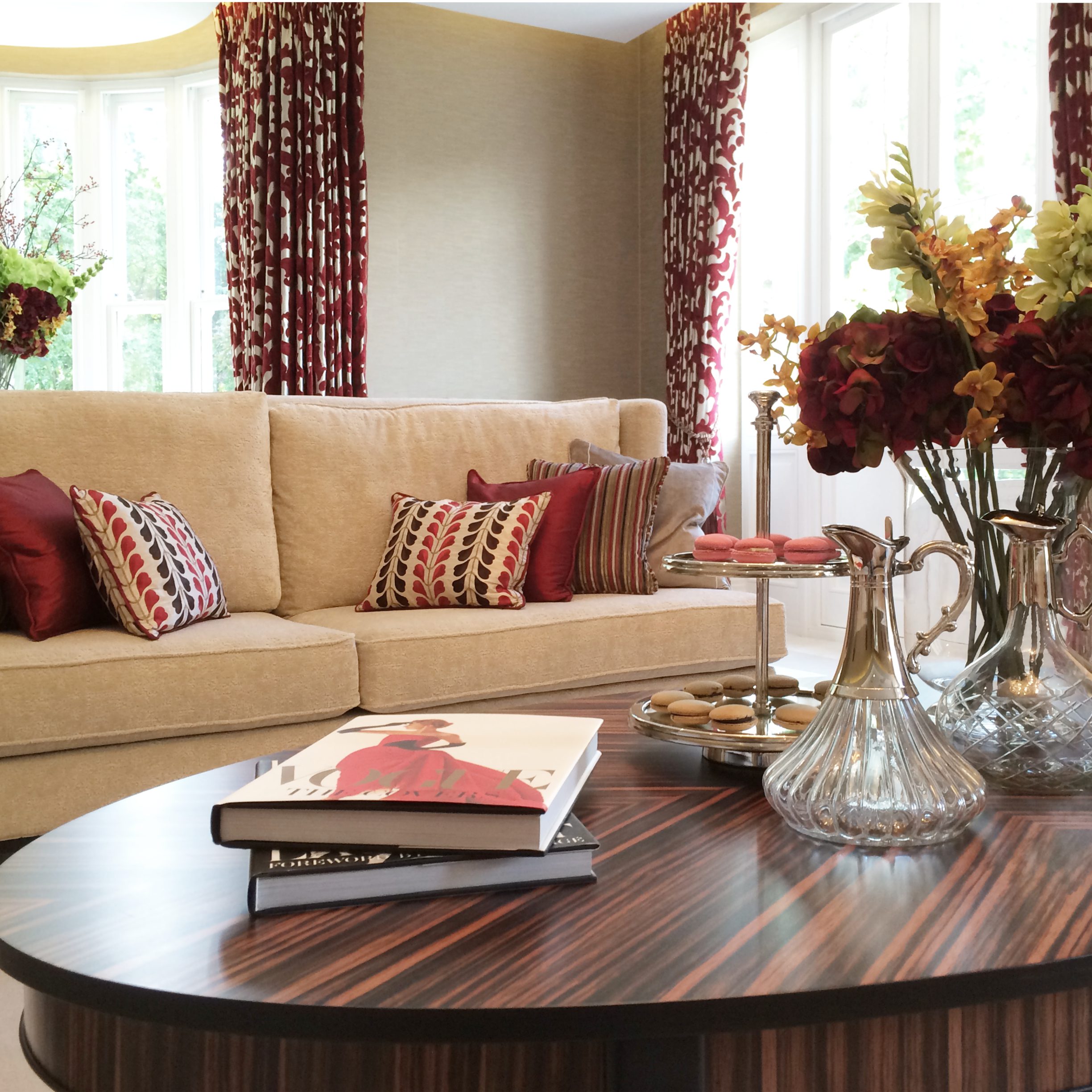 Elegant cream sofa with red cushions and a walnut coffee table