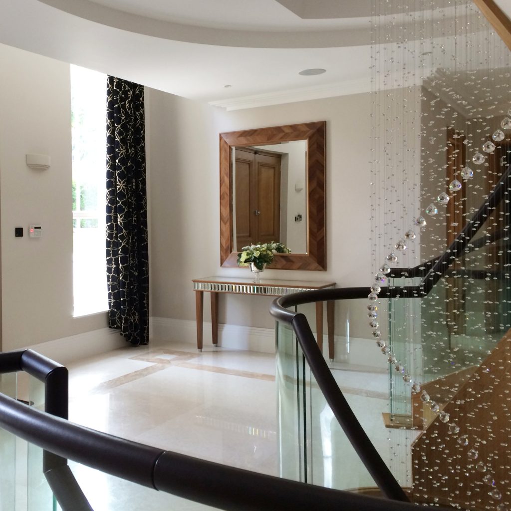 Grant entrance hall with marble floor, crystal lighting and a walnut console table with faceted mirrored detailing