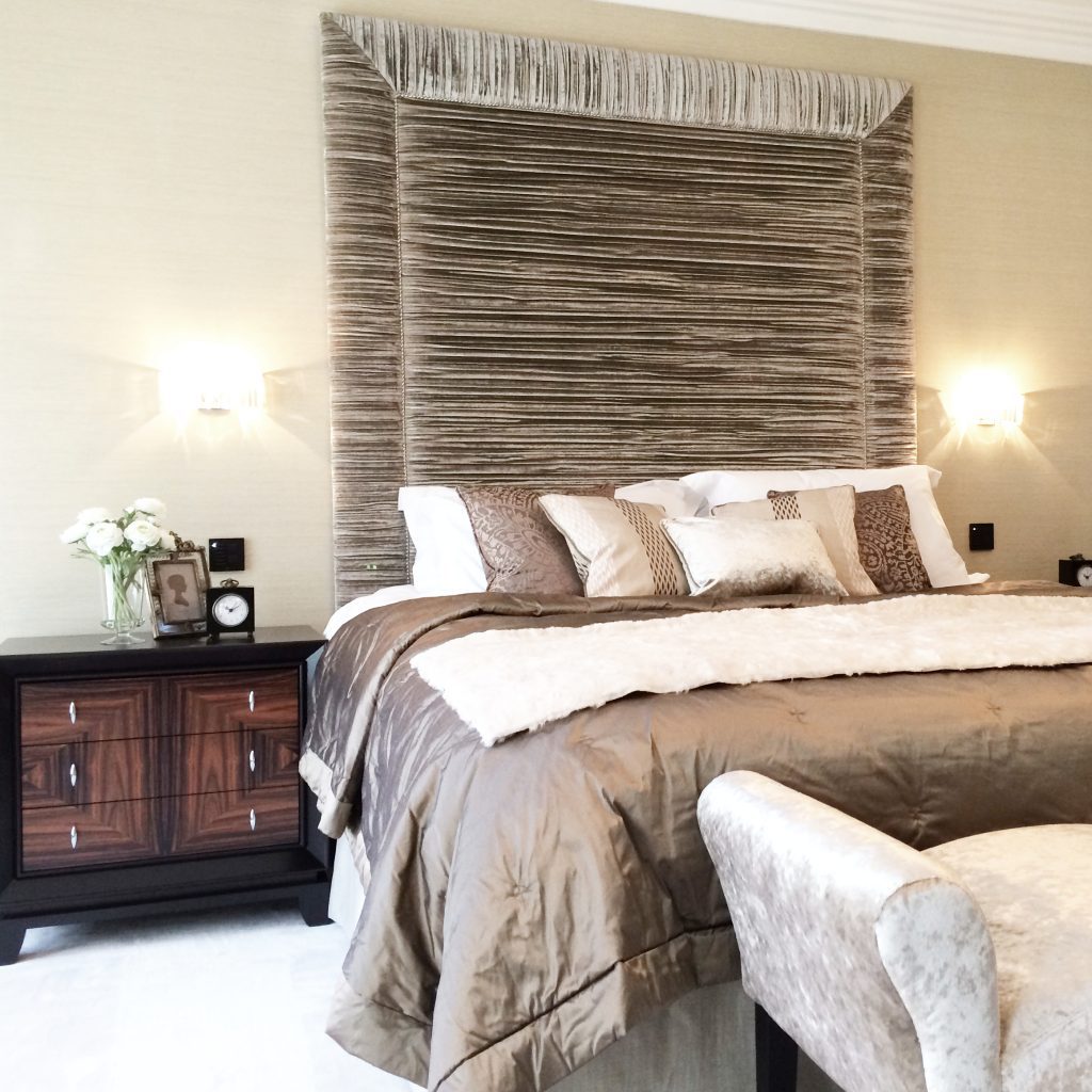 Sumptuous bedroom with dark wood bedside chests and a tall pleated velvet headboard