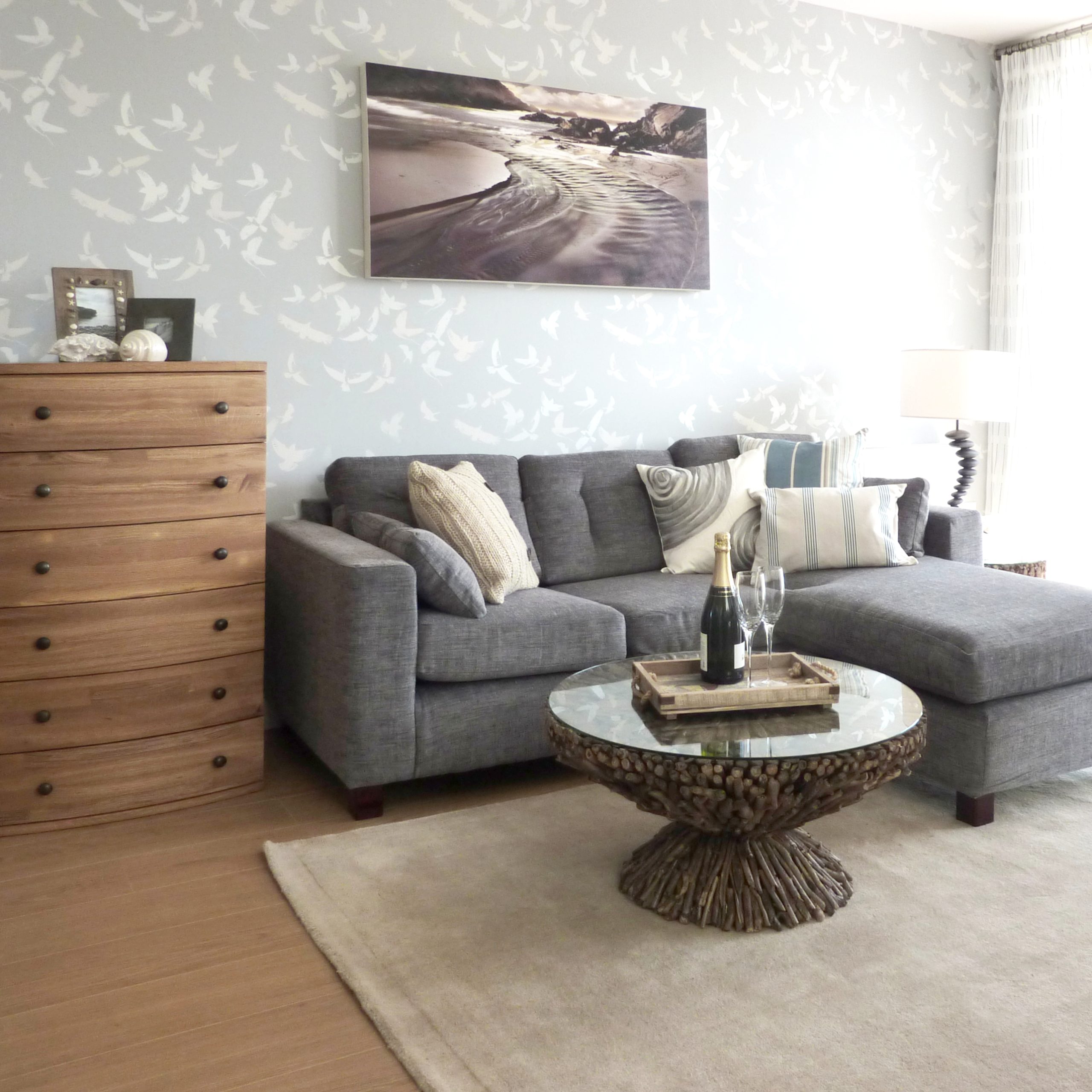 Coastal themed living room with a grey corner sofa and reclaimed teak chest