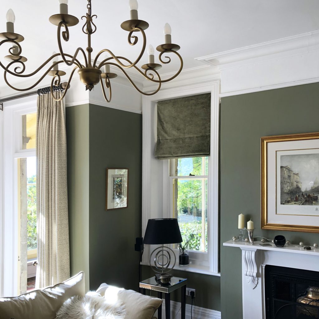 Classic, elegant drawing room with olive green walls and tweed curtains