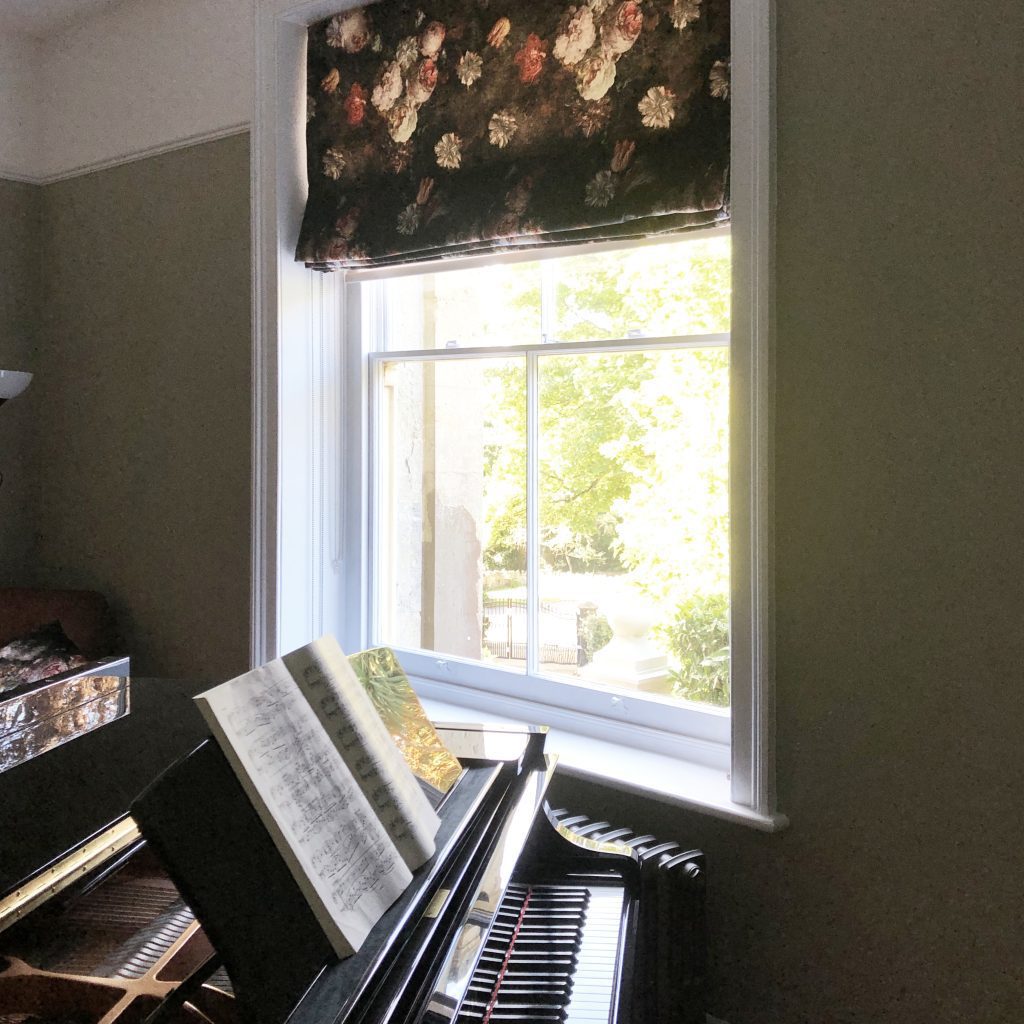 Music room painted in sage eco friendly paint with elegant floral velvet blind