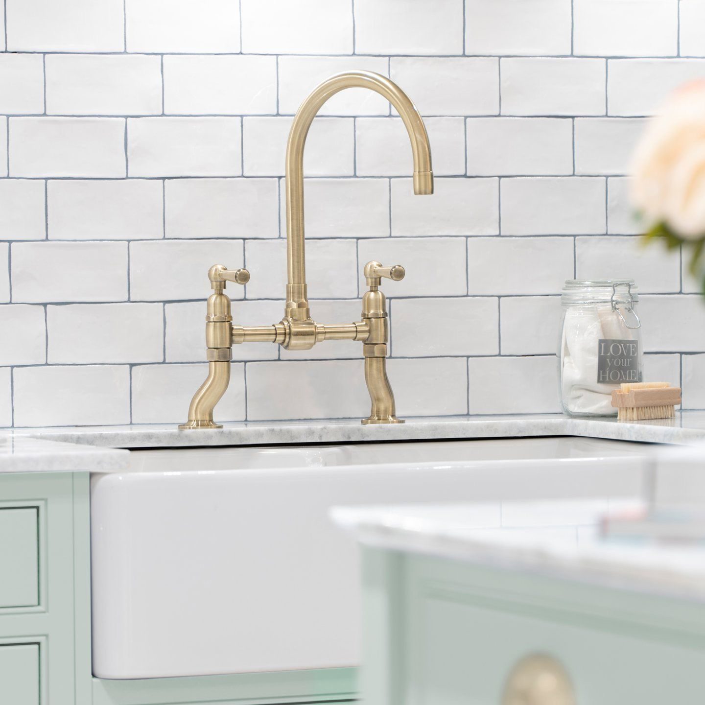 Brass bridge kitchen tap with a white ceramic butlers sink