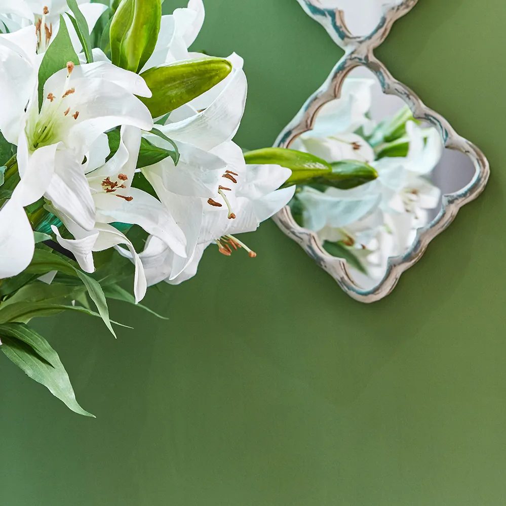 White lilies on a dark green painted background