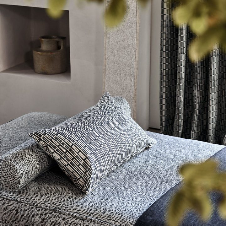 Printed linen cushion on a relaxing chaise longue.