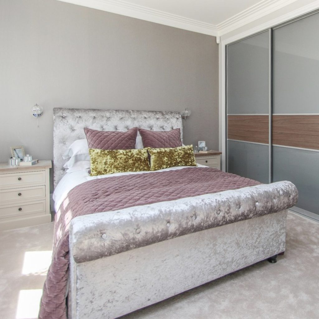 Grey bedroom with grey upholstered velvet bed and antique mauve velvet bedspread