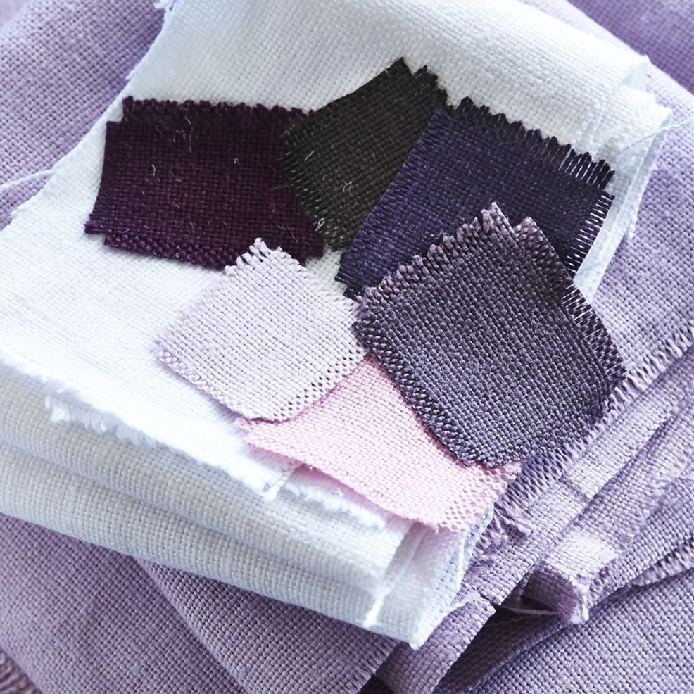 Pieces of plain linen fabric in shades of rose pink, lilac and aubergine purple.