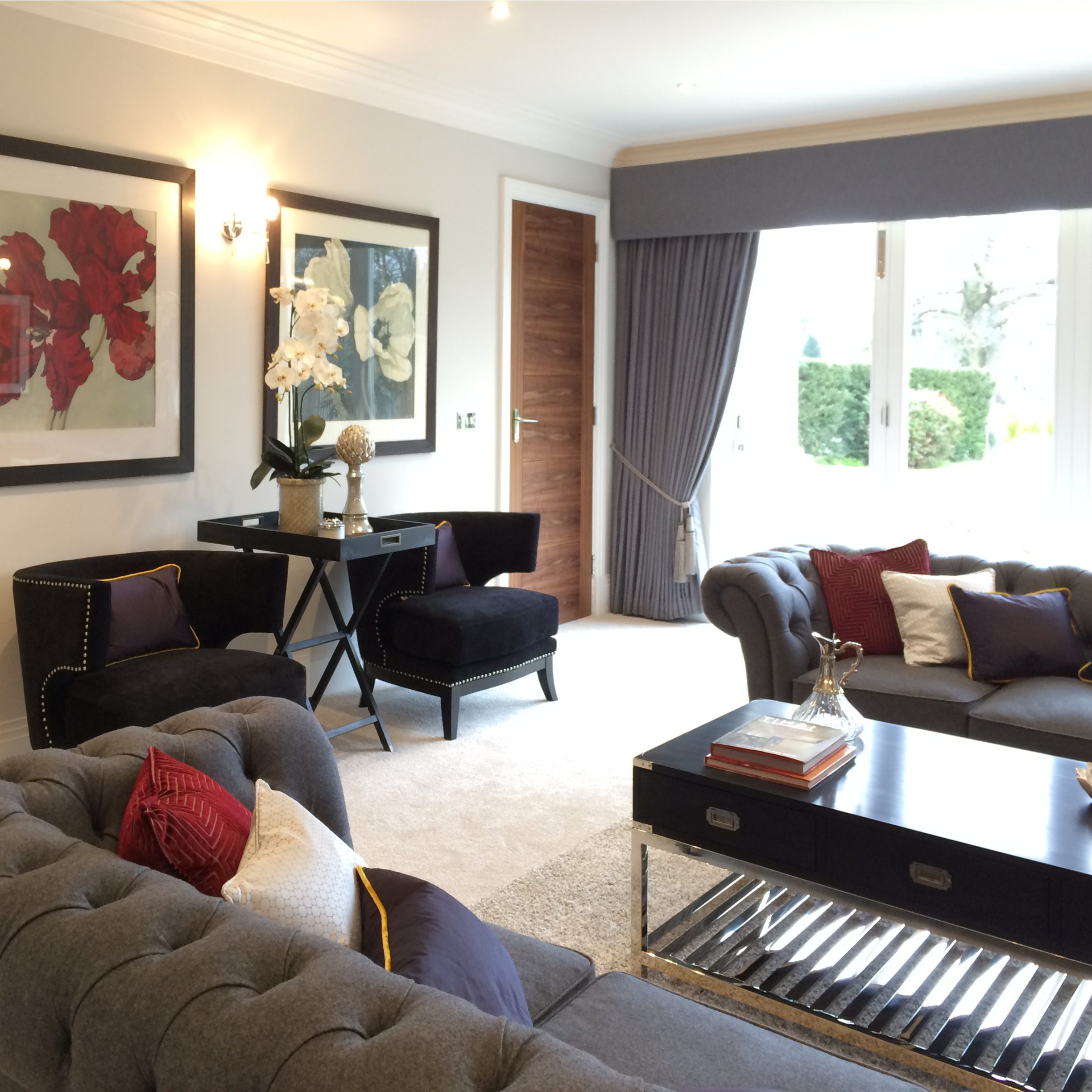 Drawing room with grey Chesterfield sofas and black side chairs