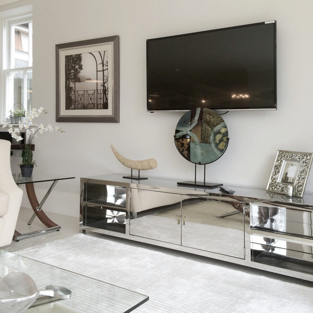 Polished stainless steel low TV unit with verdigris sculpture