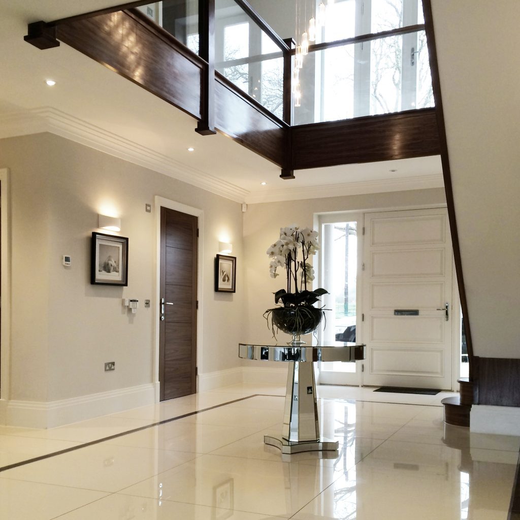 Large open entrance hall with marble floor and a mirrored table