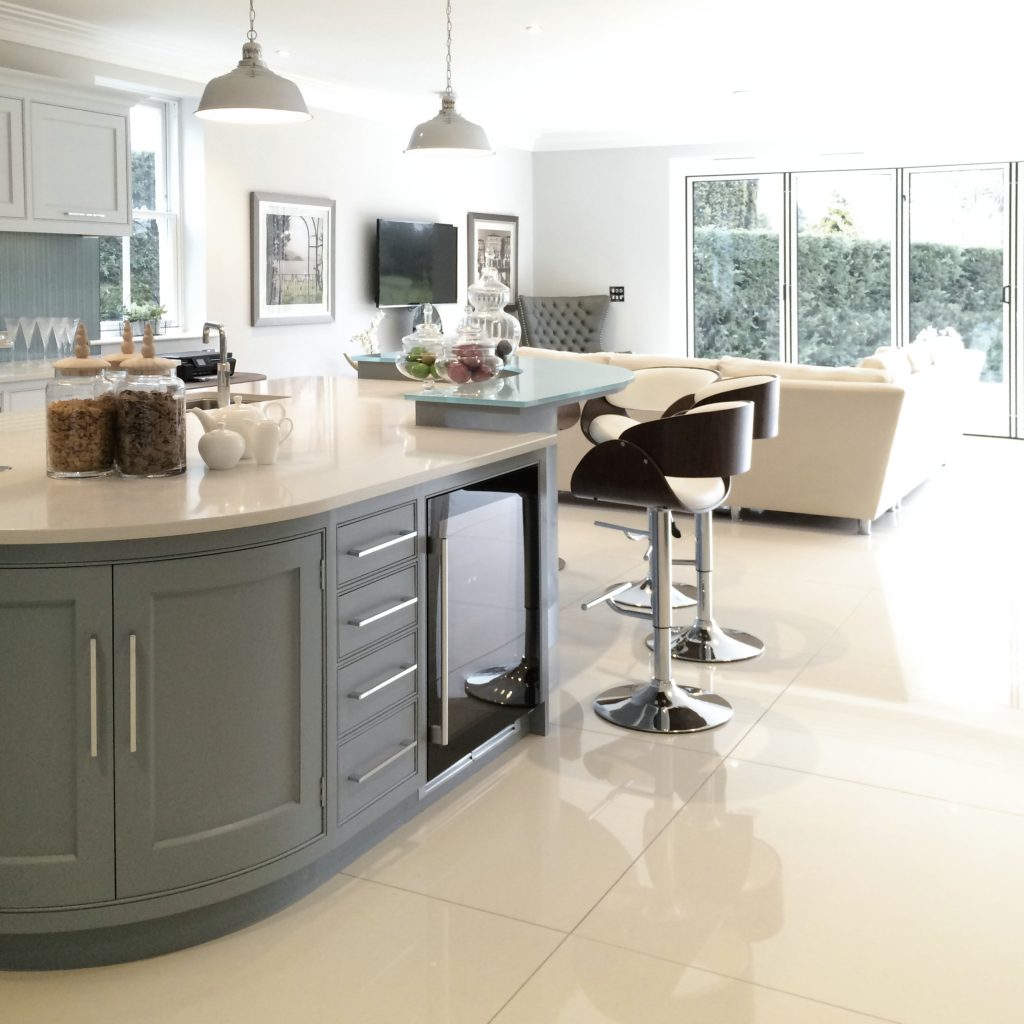 Large kitchen with painted blue shaker units and a marble floor
