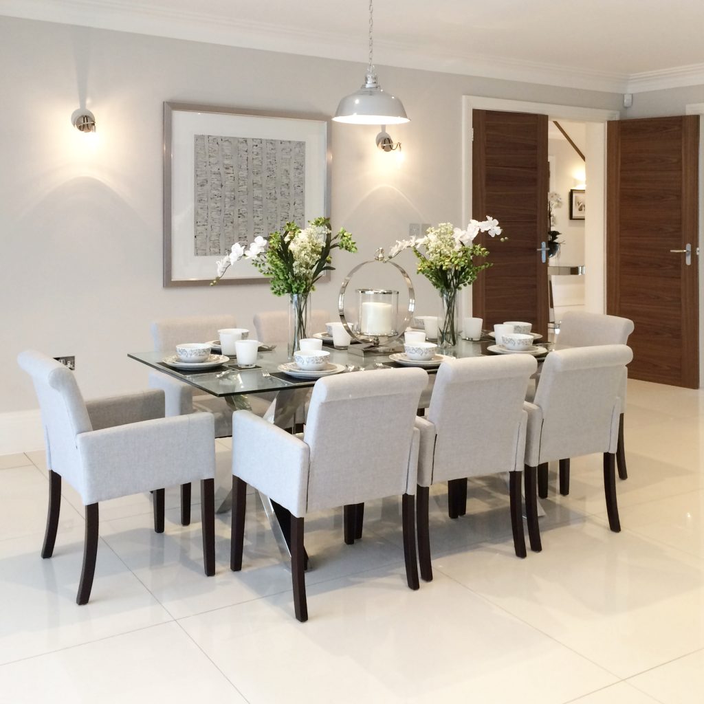Rectangular glass and stainless steel dining table with pale grey dining chairs