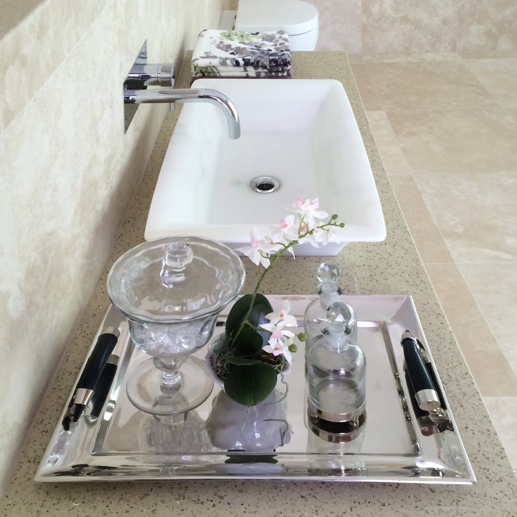 Ensuite basin unit with toiletries on a glass dish
