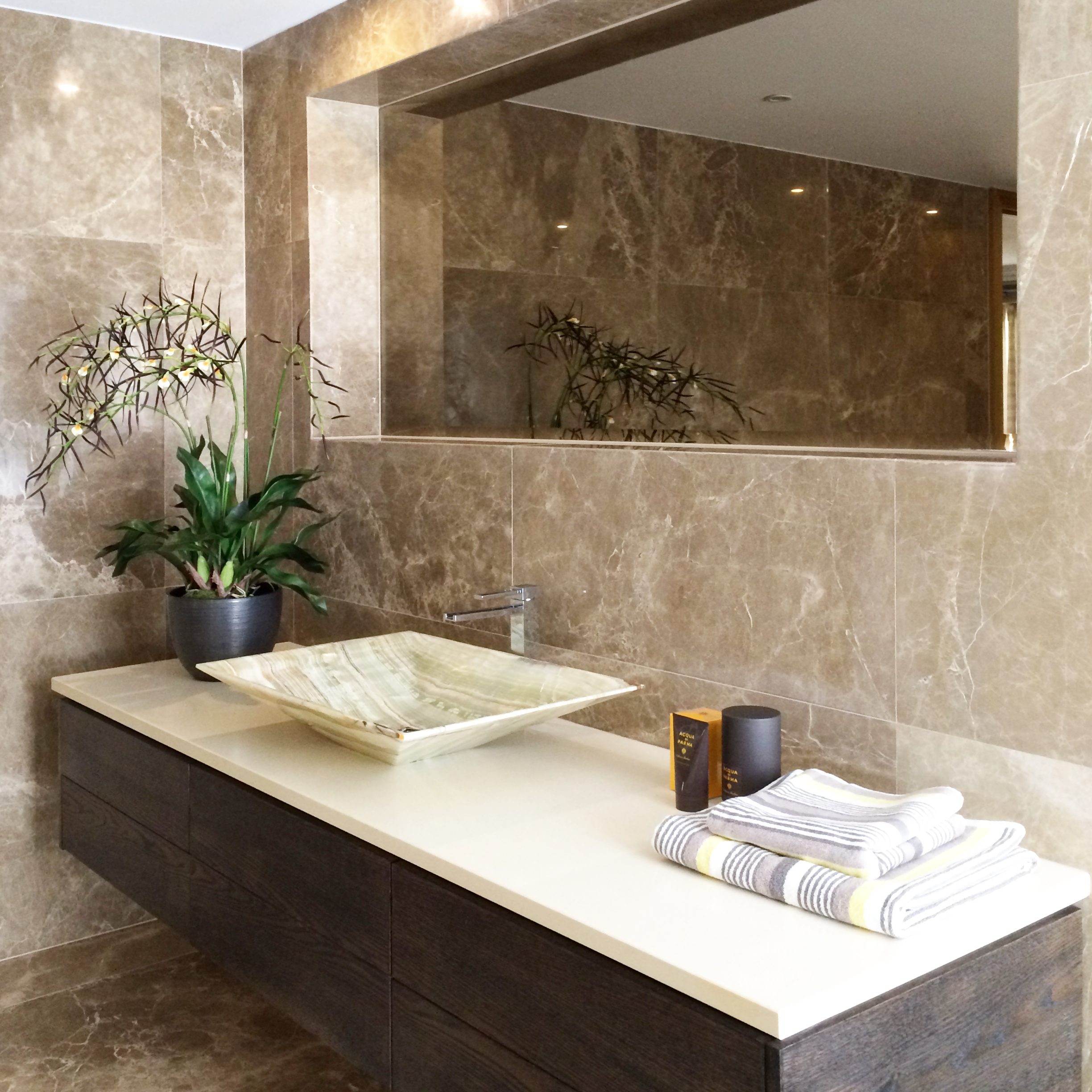 Smart masculine ensuite with large double width basin unit, onyx basin and dark marbled tiles