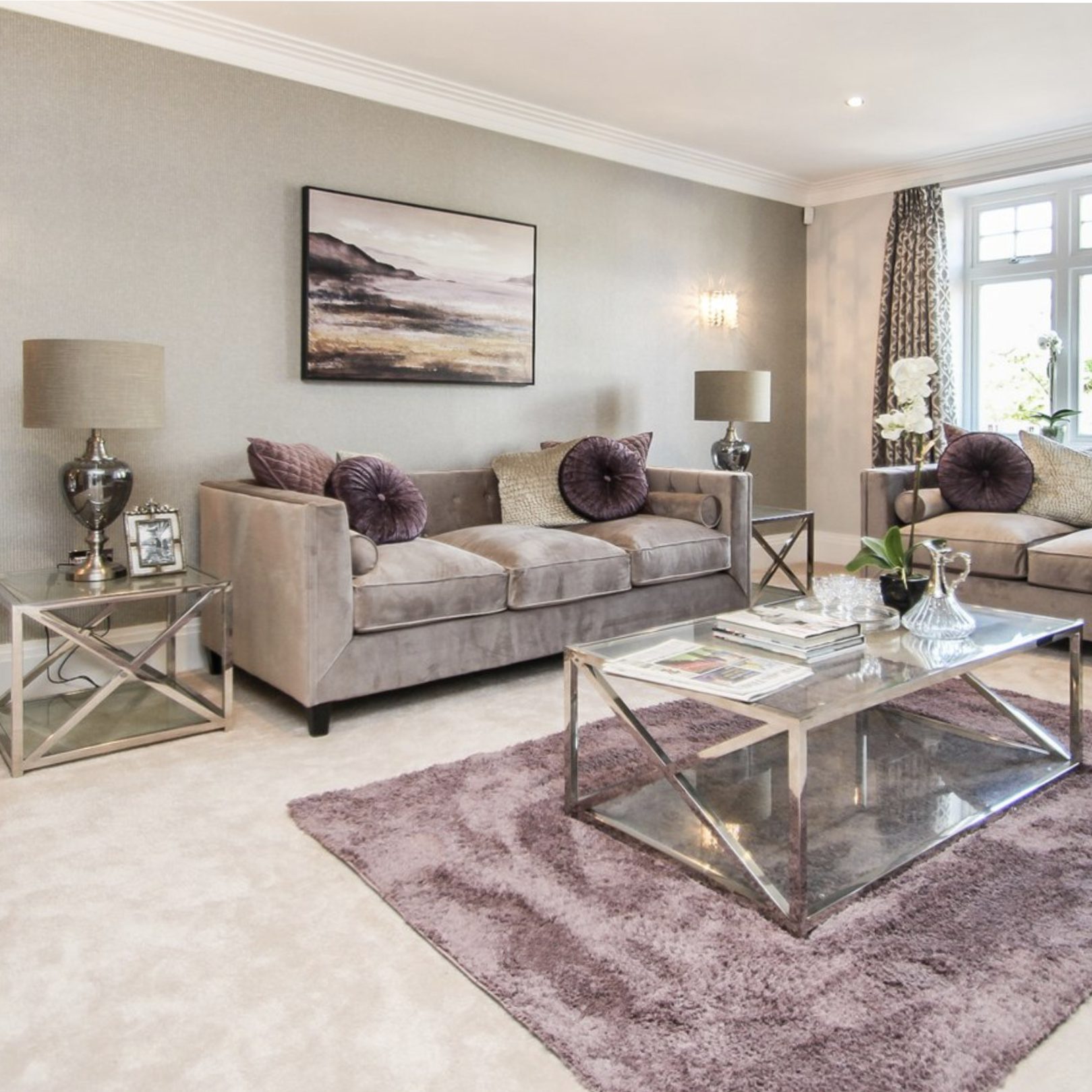 Grey living room with antique mauve accents introduced through silk cushions and a chenille rug