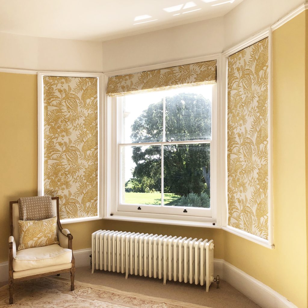 Yellow bedroom with cotton print roman blinds and classic painted walls