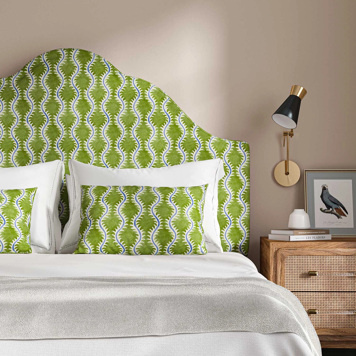 A pretty green headboard on a bed with white bedlinen