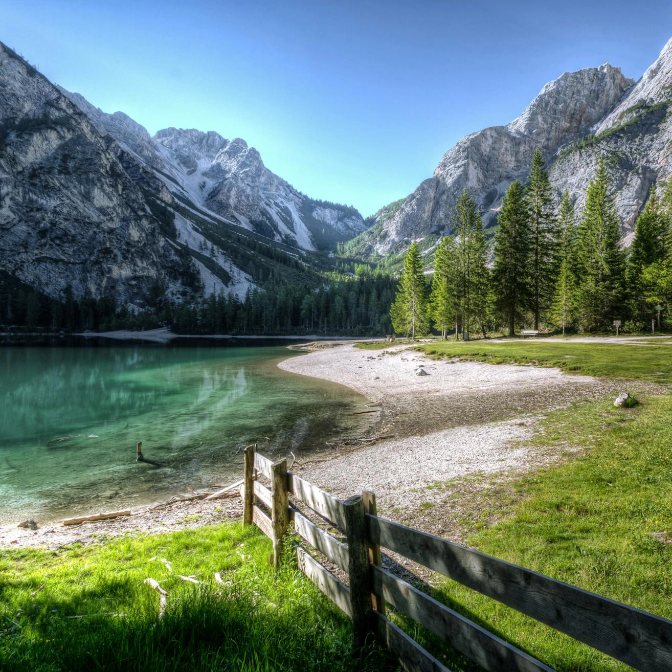 A crystal clear lake with a backdrop of mountains and forest