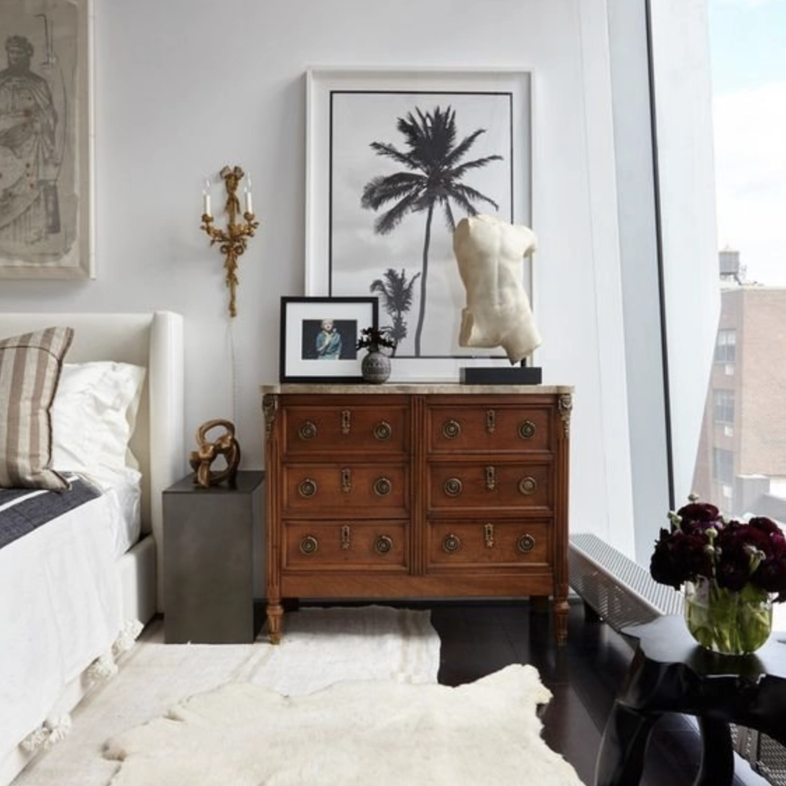 A tranquil neutral bedroom with a mix of modern and antique furniture