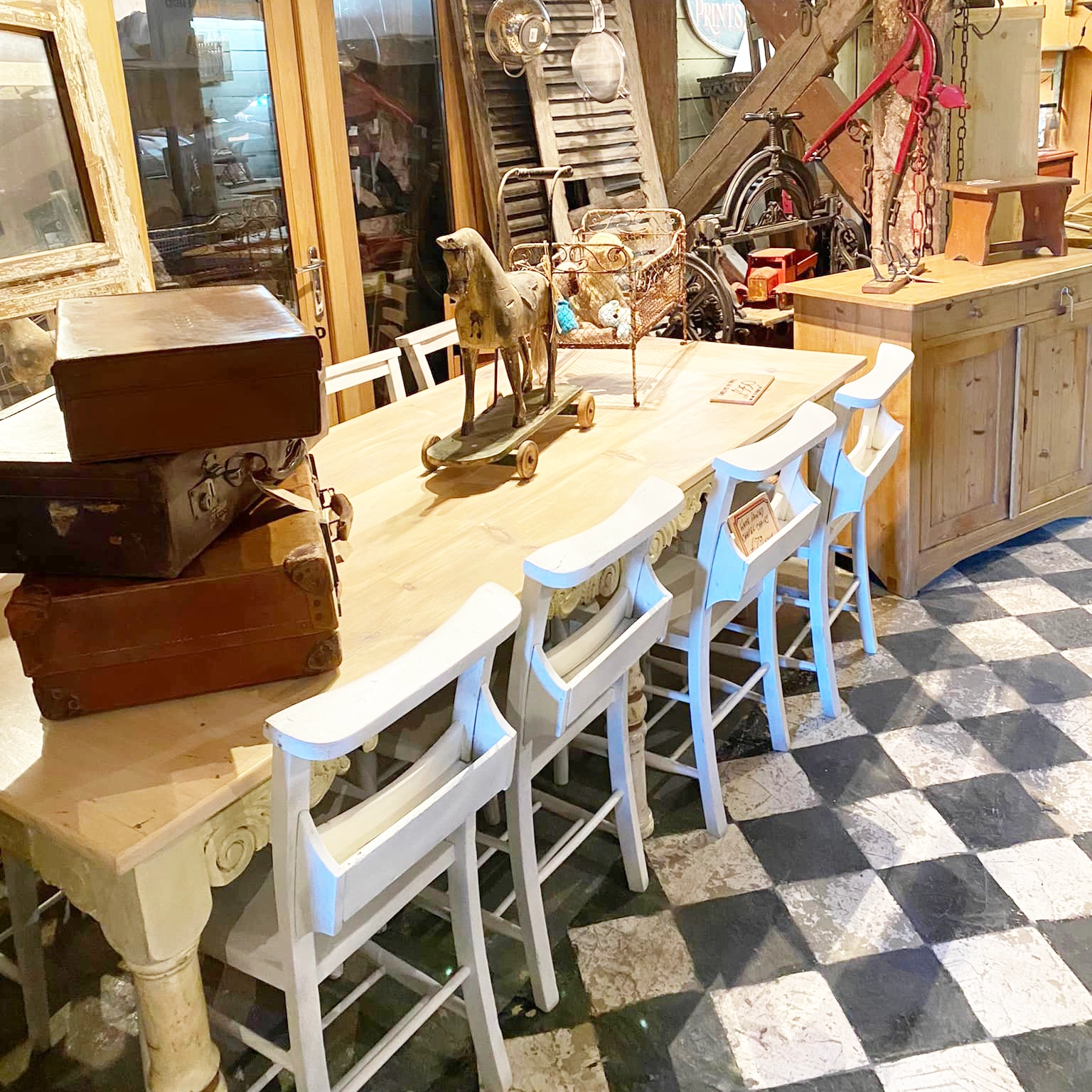 Pine table and chairs and other items in an antiques warehouse