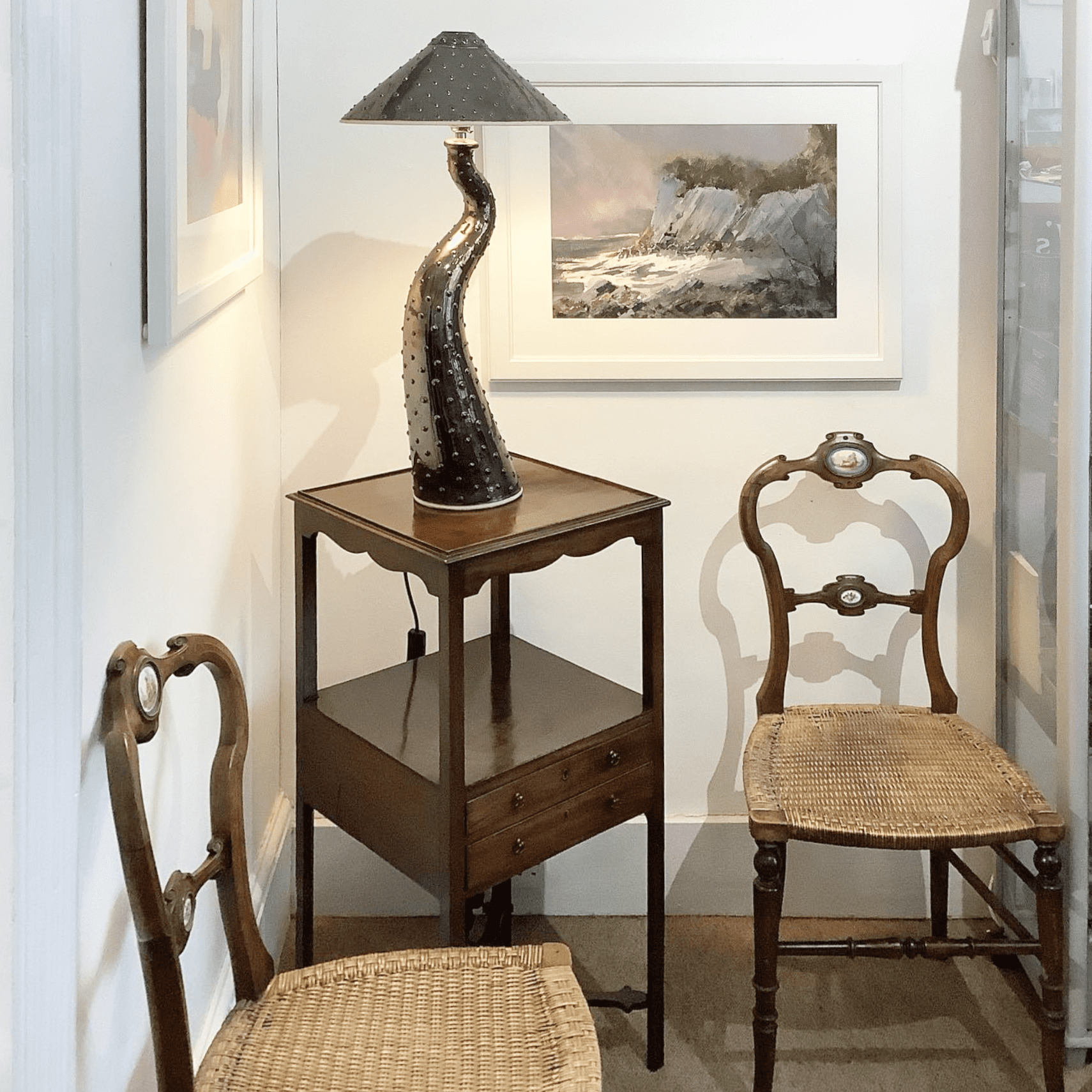 Two elegant dining chairs and a two tier table in an antique shop