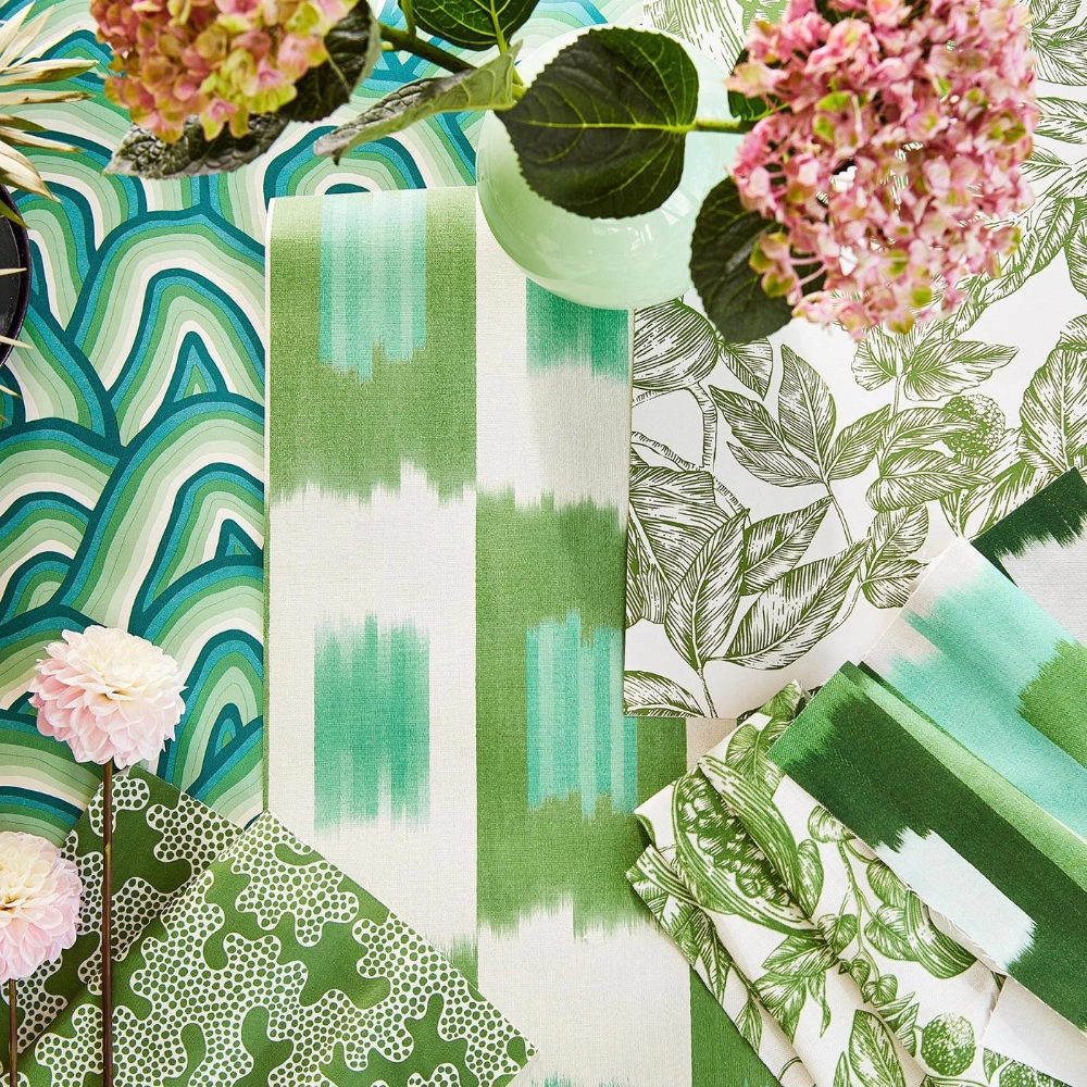 A collection of wallpaper and fabric samples in various shades of green