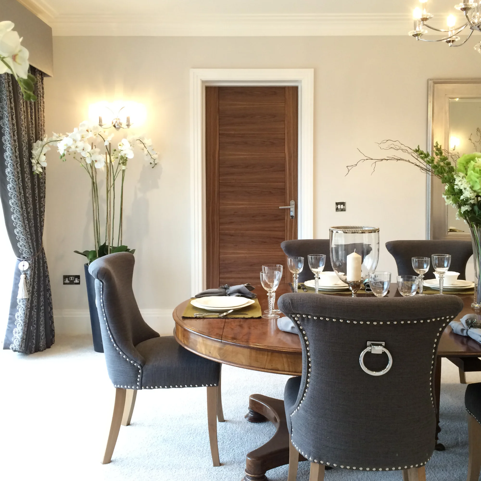 A modern dining room with an antique dining table and grey chairs