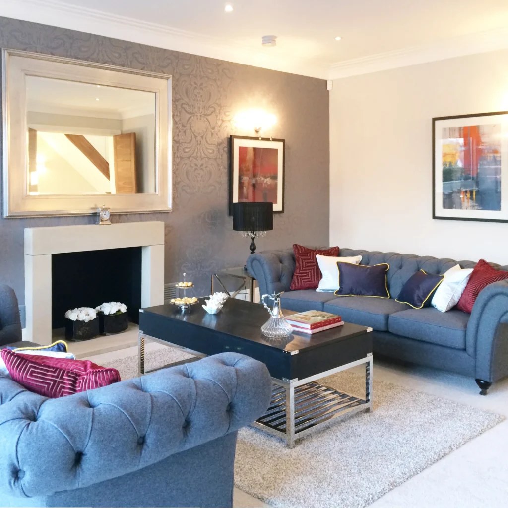 A living room with grey Chesterfield sofas