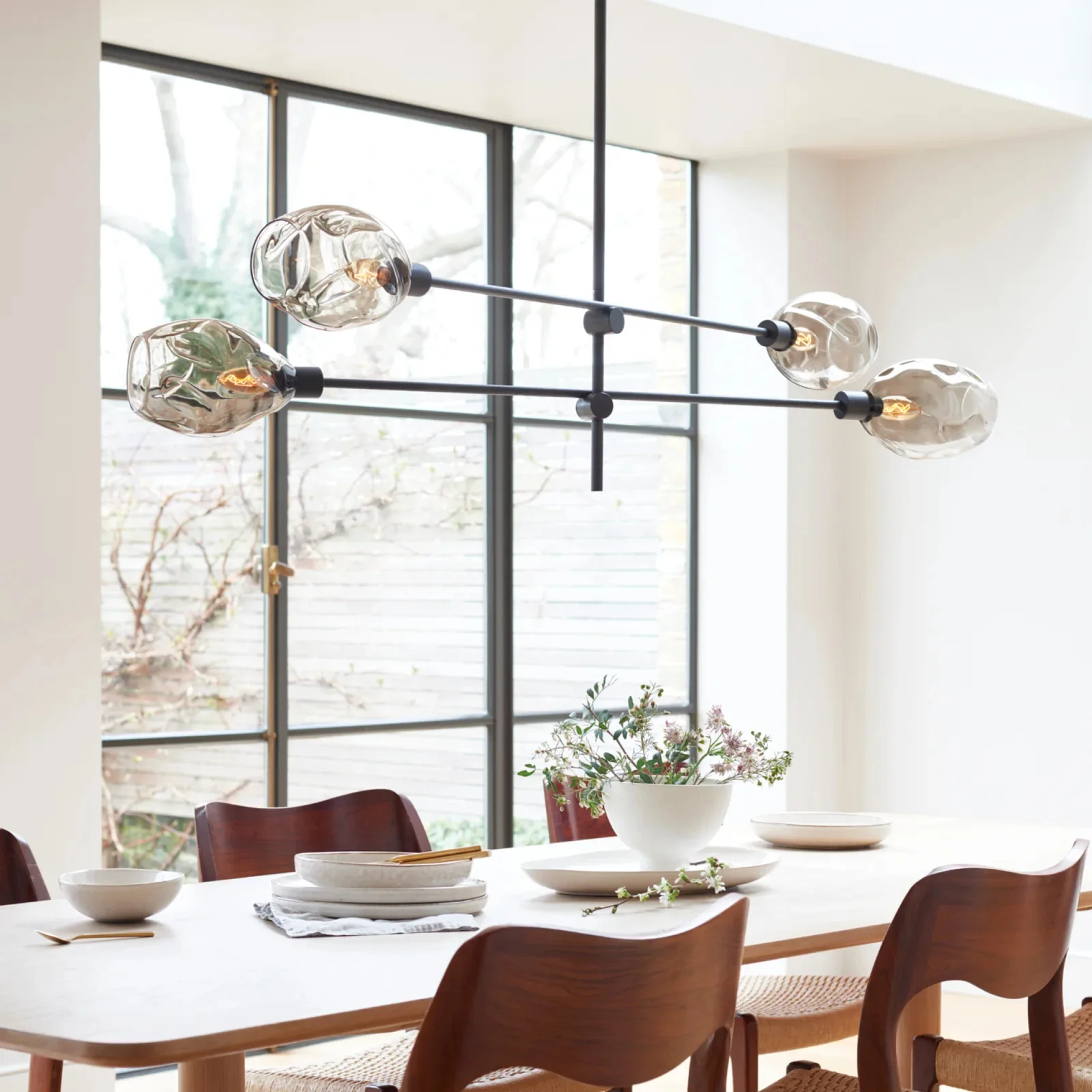 A modern light fitting suspended above a dining table