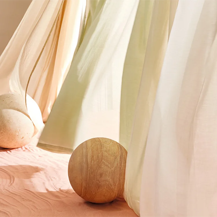 Voile curtains being blown in the breeze through a window