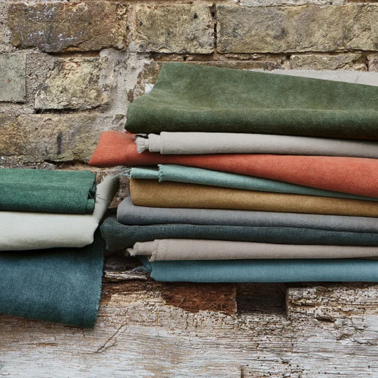 A stack of cotton fabrics in ocean and autumnal shades